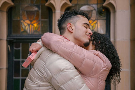 couple hugging and woman has valentine's gift for him