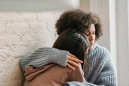 two women hugging for stress relief