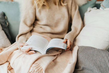 Woman reading on couch for a relaxing thing to do at home