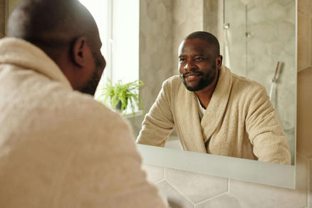 man looking at face in mirror