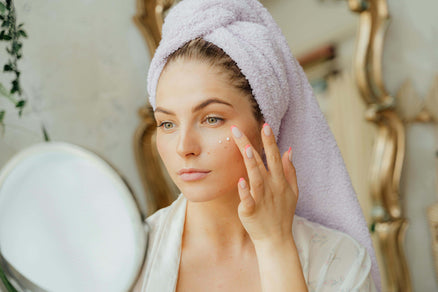 woman looking in mirror for face skincare