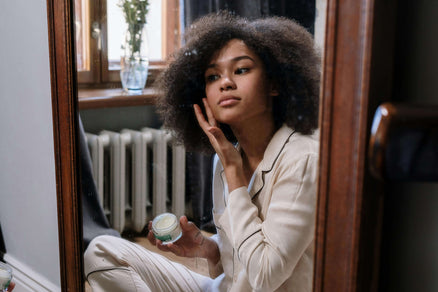 woman applying skincare to face