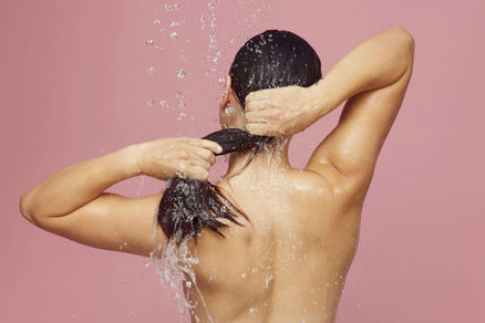 Woman washing hair to repair damaged hair at home