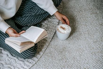 A person holding book and tea to show how to unplug