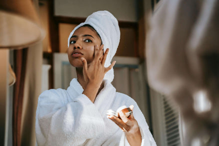 Woman applying face moisturizer to hydrate skin overnight