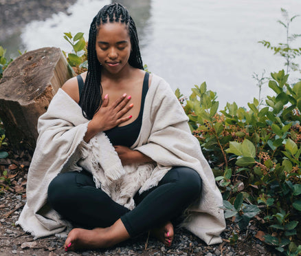 Woman outside meditating to reconnect with herself