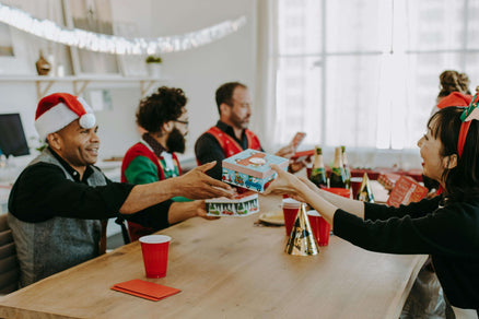 men and women exchanging Secret Santa gifts