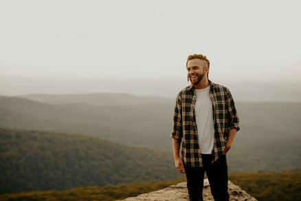 man smiling backed by mountains
